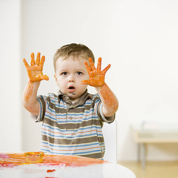 boy-2-3-holding-up-hands-covered-with-fingerpaint-at-home-andersen-ross.jpg
