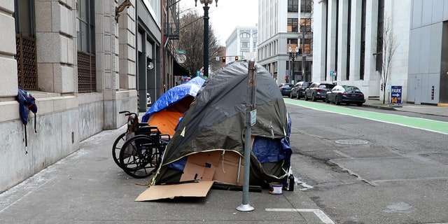 Tents and a wheelchair cover a sidewalk in downtown Portland