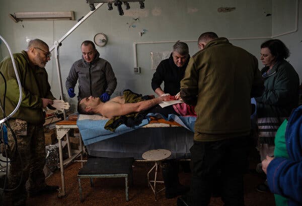 A team of doctors from a frontline stabilization point in the Donbas bandage the hand of a civilian named Serhii, who was hit by shrapnel while collecting wood last week.